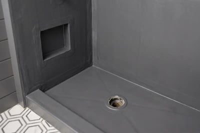 Waterproofing membrane over the shower pan with a wrapped niche and bonded drain before tile — Hybrid Renovations