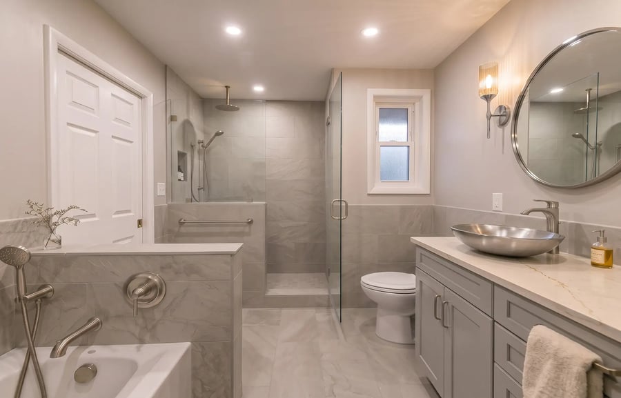 Finished bathroom with a tiled walk-in shower, knee wall and vessel sink vanity after a full remodel