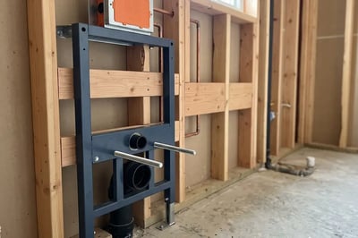 Steel carrier frame and concealed tank set for a wall-hung toilet during bathroom remodel rough-in