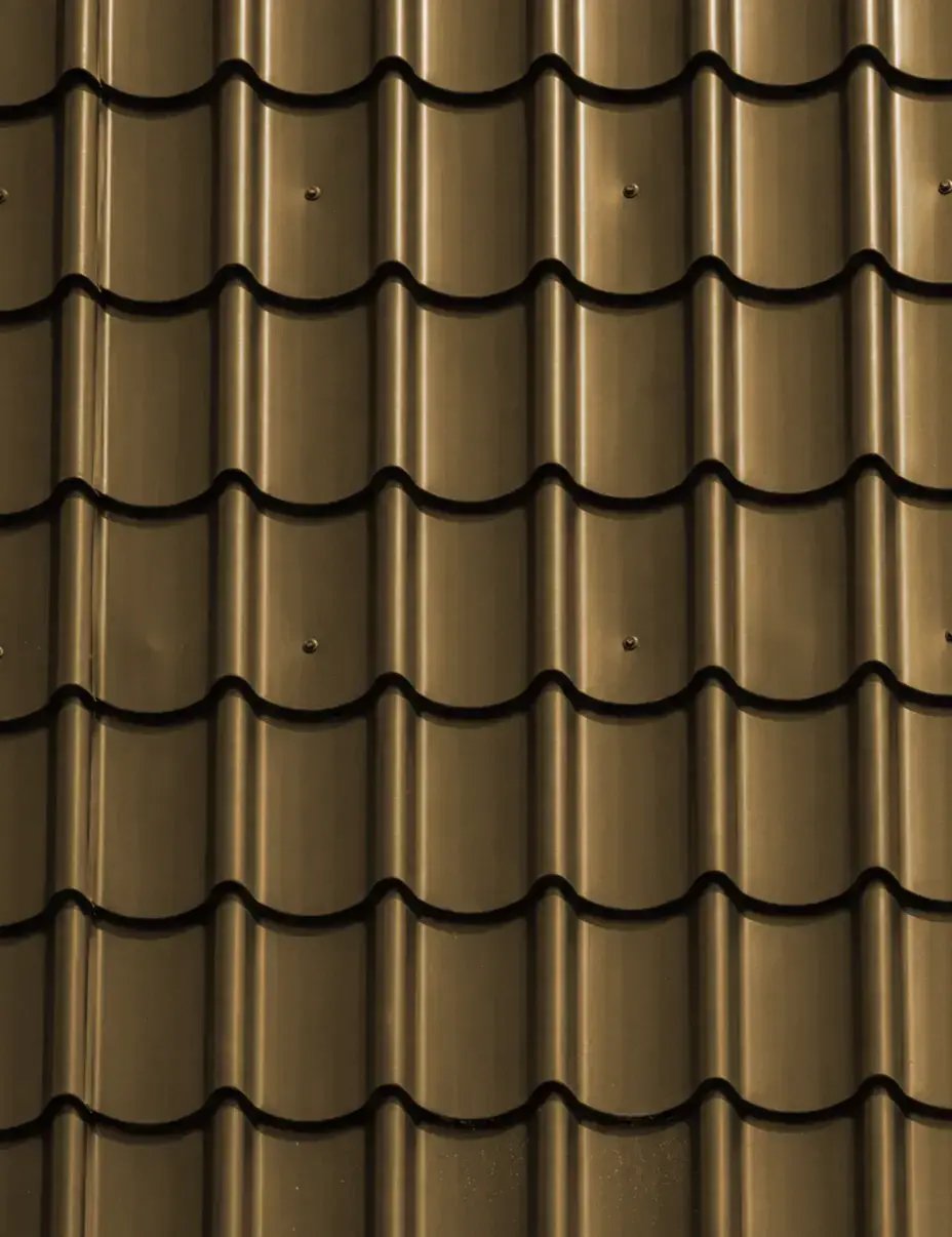 Warm bronze standing seam metal roofing color sample with glossy vertical panel ribs — Hybrid Renovations
