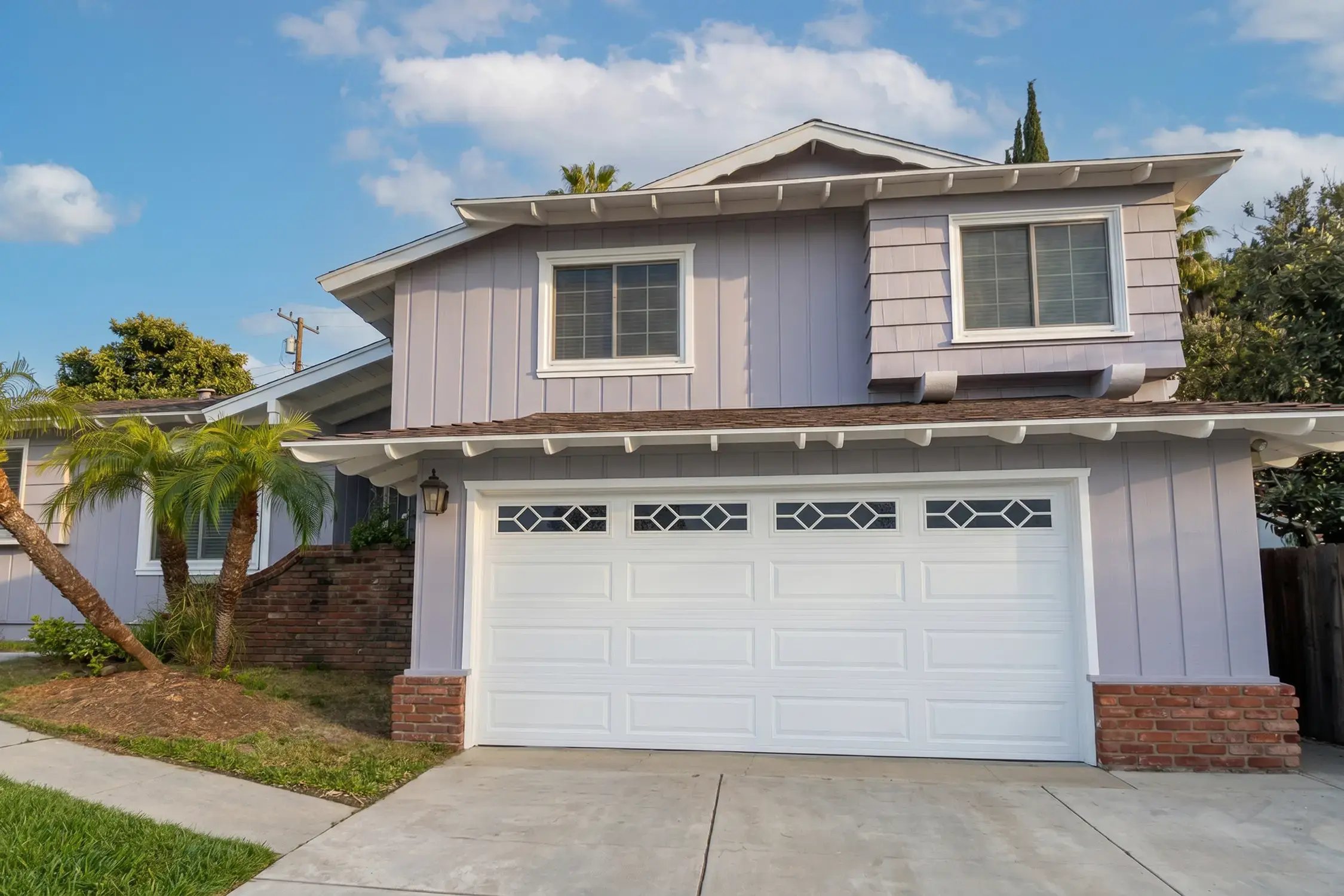 Two-story front elevation in warm gray with white trim after exterior repaint by Hybrid Renovations, Hacienda Heights