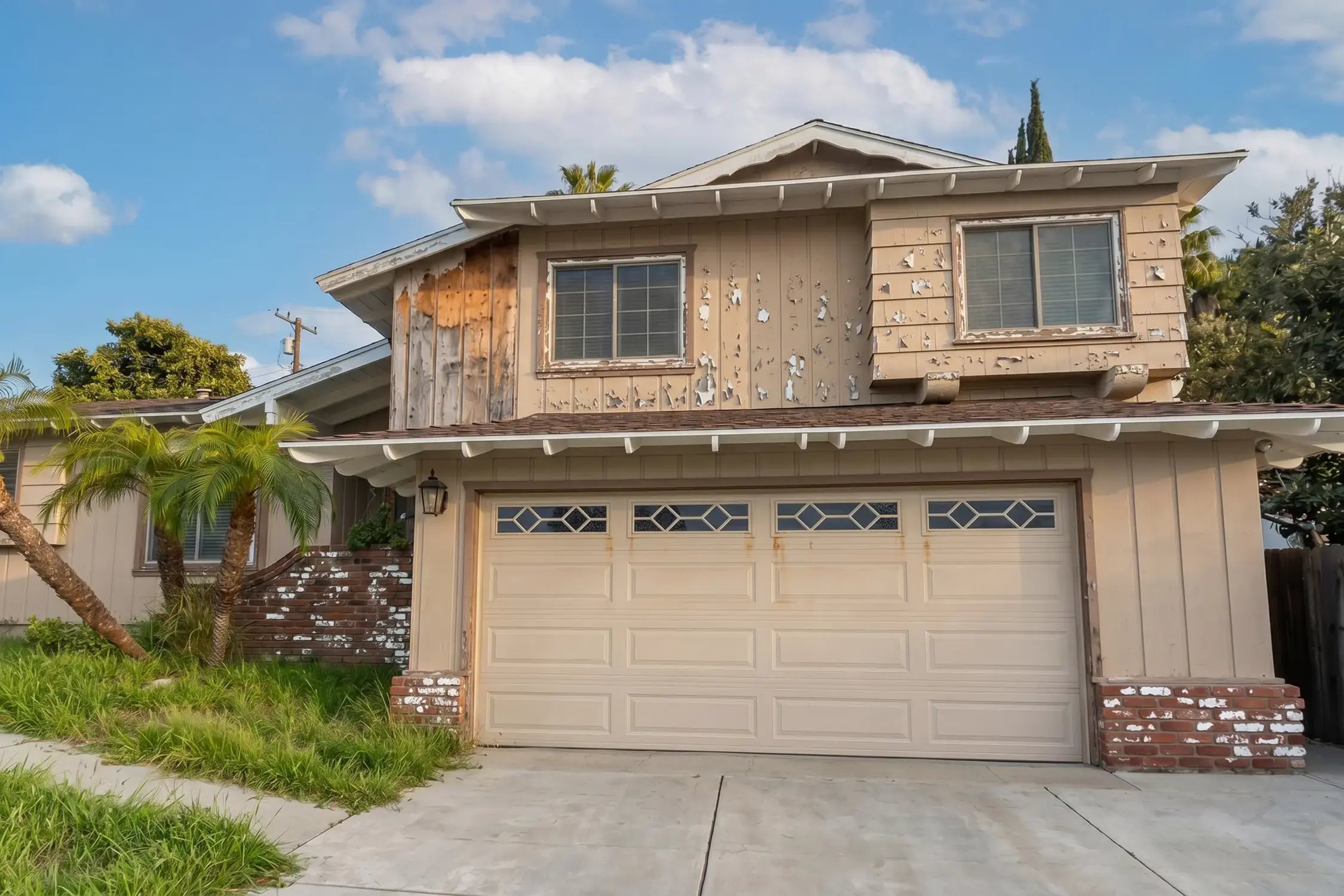 Two-story home with peeling, failing paint across the upper siding before exterior coating, Hacienda Heights