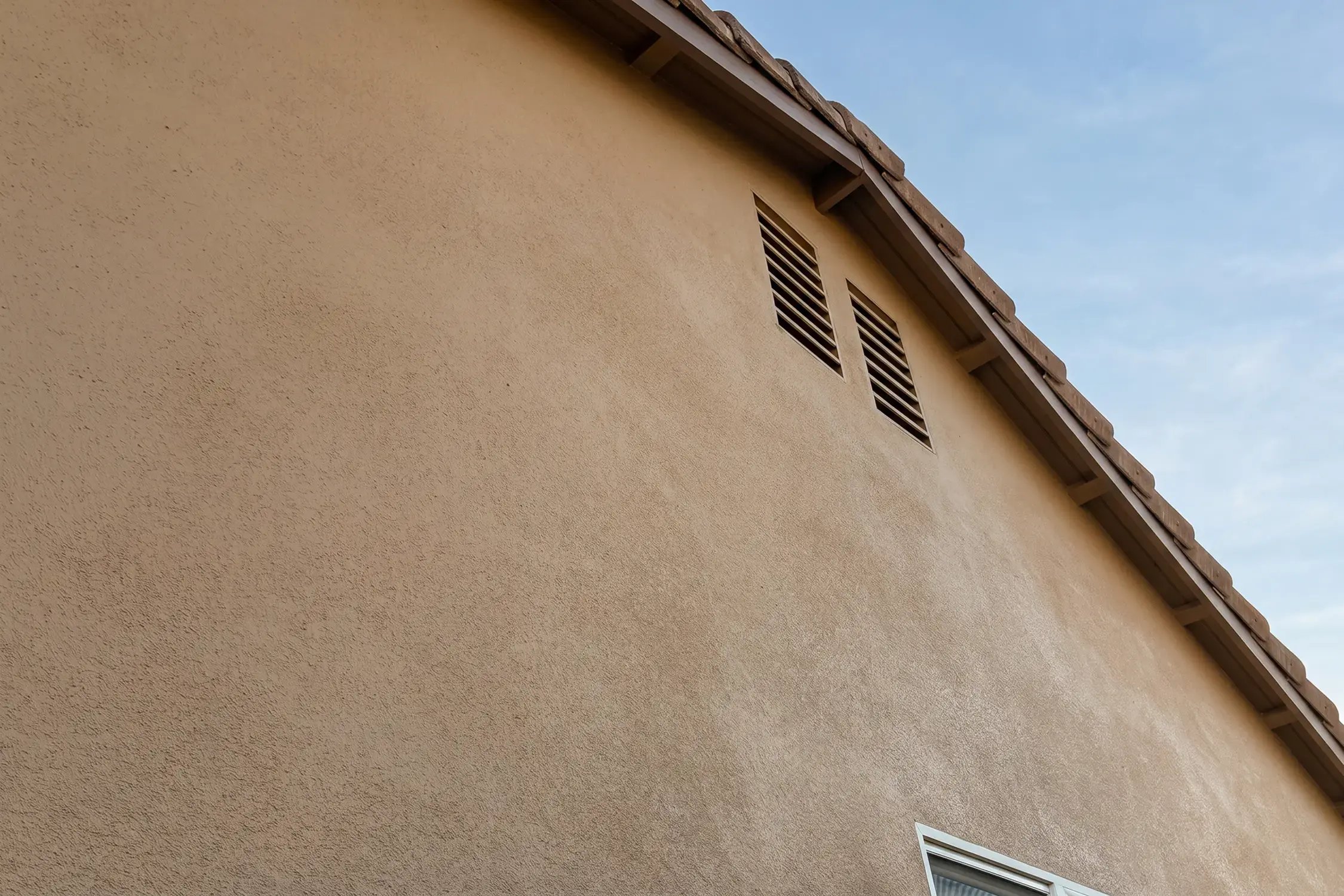 Gable wall and two attic vents recoated to match the Tailored Tan stucco finish, Glendora