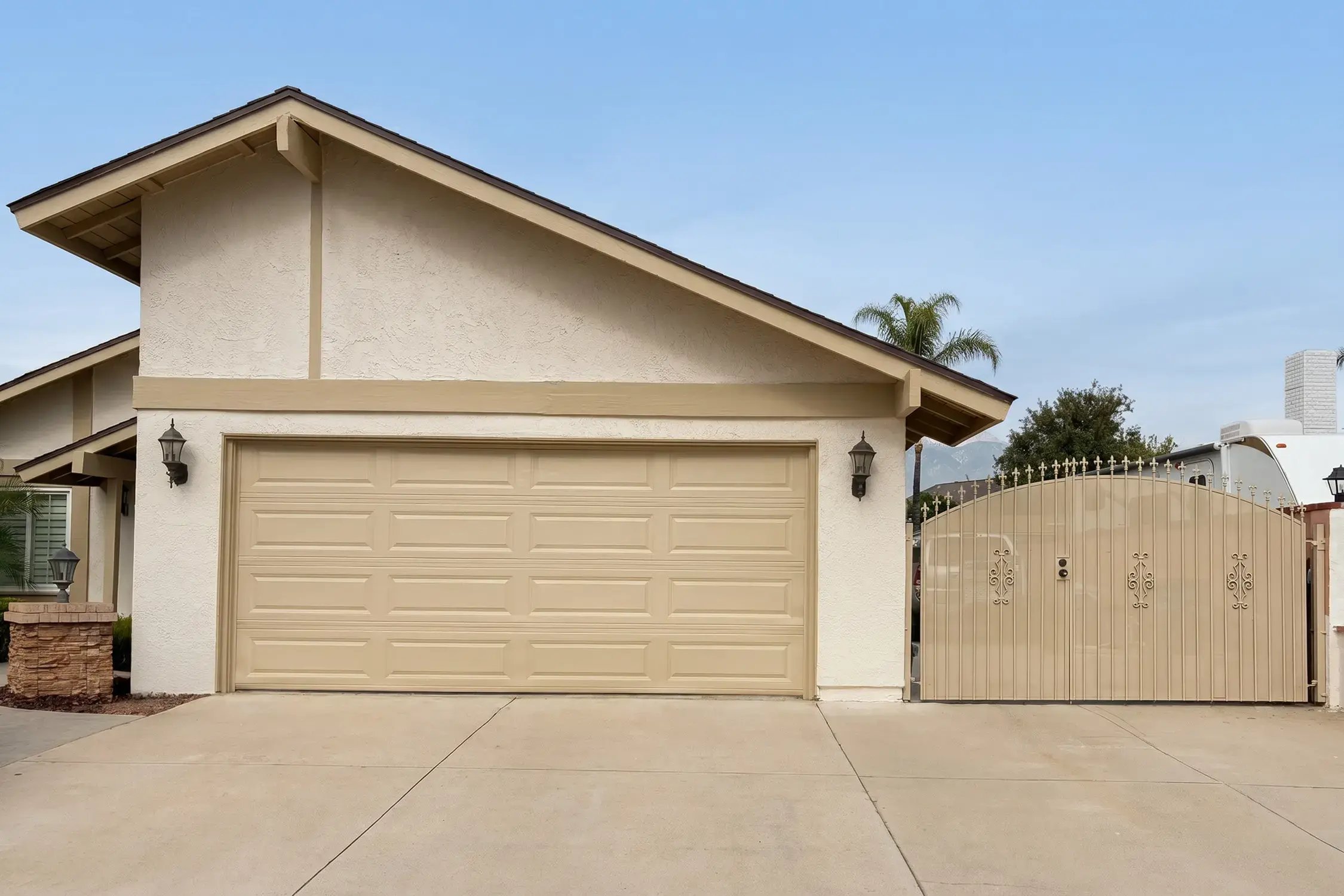 Tan stucco garage elevation in COOLWALL French White with Sandalwood trim after Hybrid Renovations repaint, Ontario