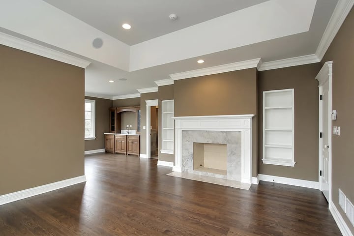 Empty living room with taupe walls and white trim after move-in interior repaint — Hybrid Renovations