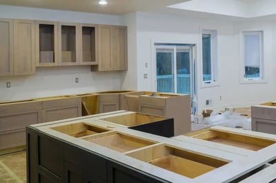 Kitchen cabinets and island boxes set in place mid-install, awaiting doors and countertops
