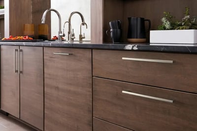 Walnut slab-front kitchen cabinets and drawers with long brushed nickel bar pulls