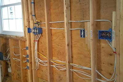 Kitchen electrical rough-in with labeled circuits, switch boxes and cable runs on open framing