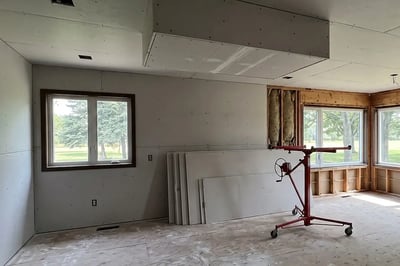 Drywall hung on the ceiling and walls with seams unfinished during a full kitchen gut renovation