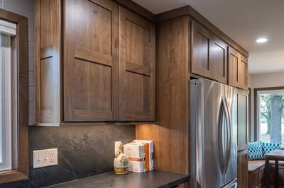 Walnut shaker cabinets with a dark soapstone counter and backsplash after a full kitchen renovation