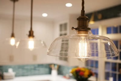 Seeded glass pendant light with an aged brass fitting and Edison bulb hung over a kitchen counter