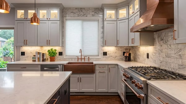 Grey shaker cabinets, quartz counters, a copper hood and farmhouse sink after a kitchen remodel