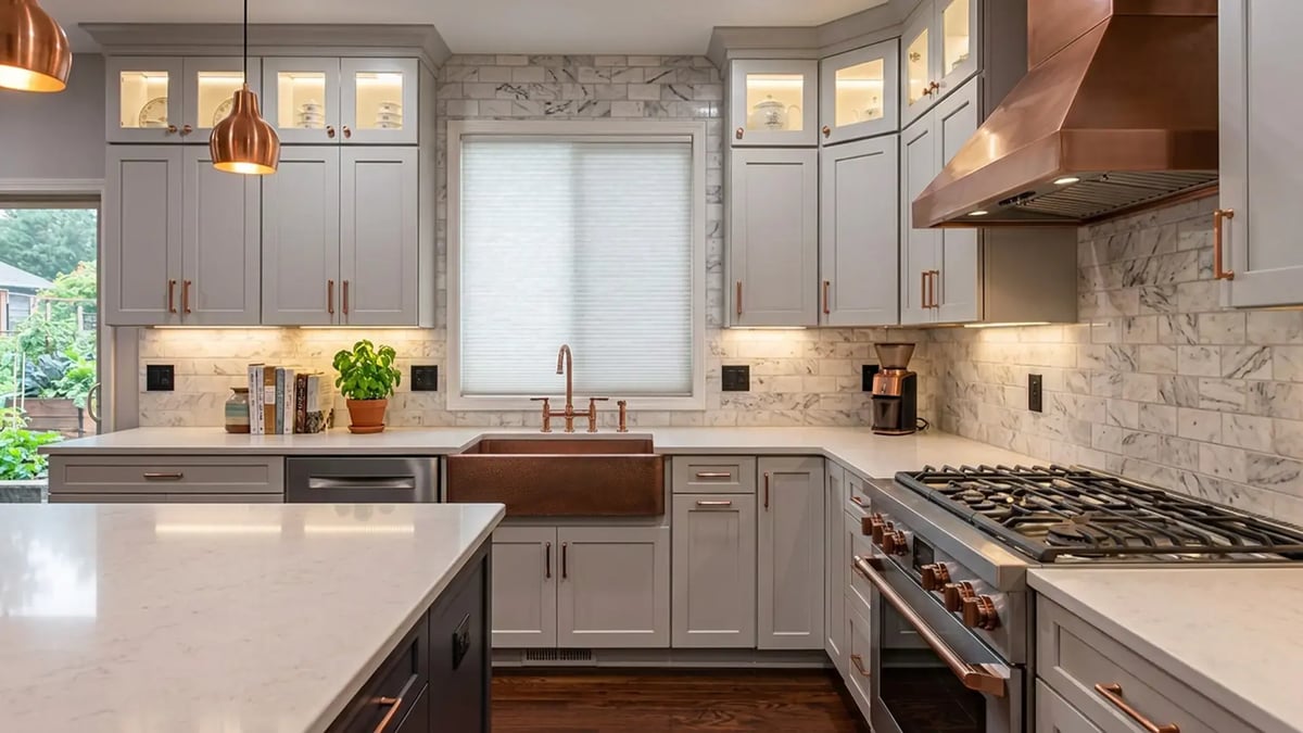 Grey shaker cabinets, quartz counters, a copper hood and farmhouse sink after a kitchen remodel
