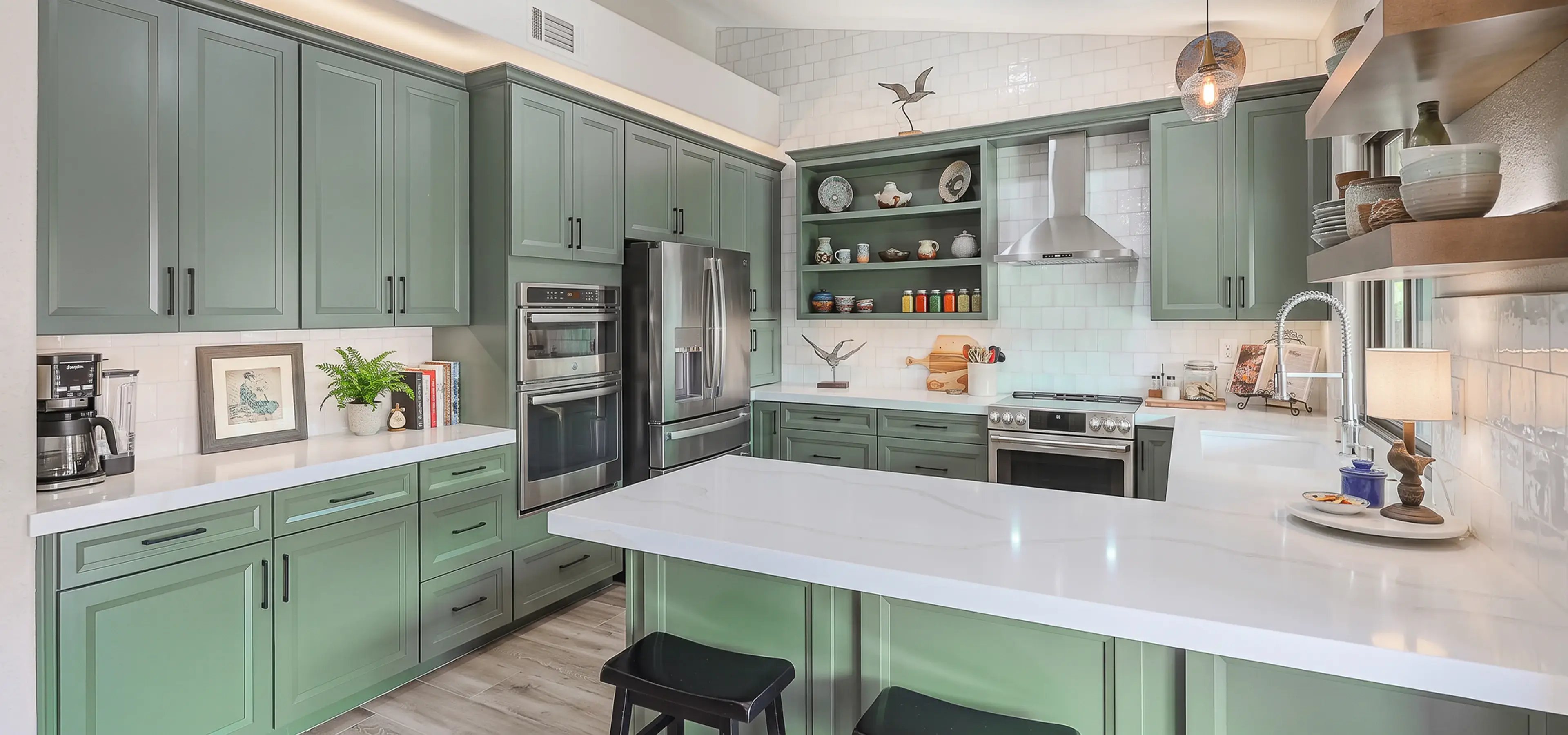Sage green shaker cabinets, white quartz counters and a subway tile backsplash in a remodeled kitchen