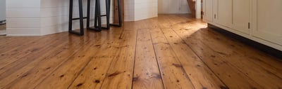 Wide plank pine flooring running from the peninsula through to the open concept living area