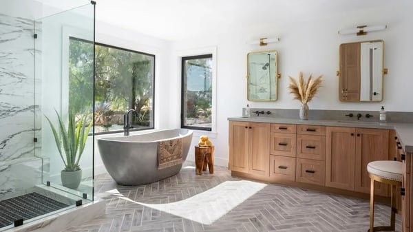 Freestanding soaking tub, marble slab shower and double wood vanity after a primary bathroom remodel
