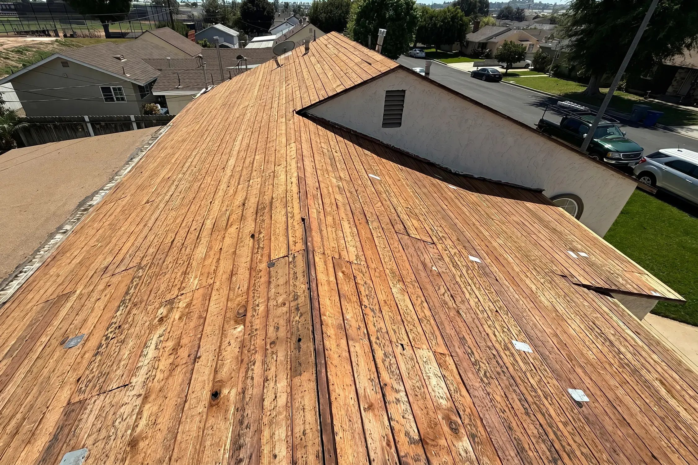 Roof stripped to bare wood plank decking during tear-off by Hybrid Renovations before new shingles, La Habra