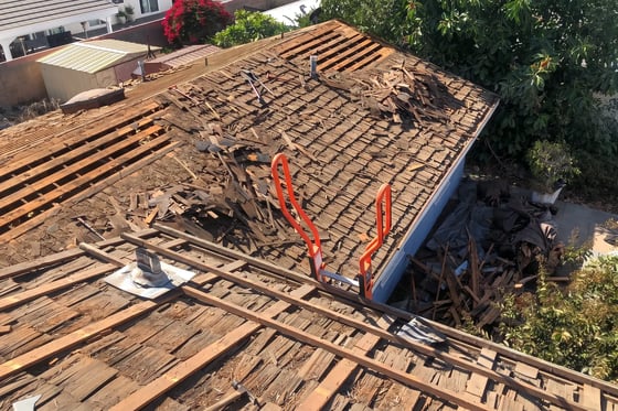 Old wood shake and skip sheathing torn off down to the rafters on an Orange County roof replacement