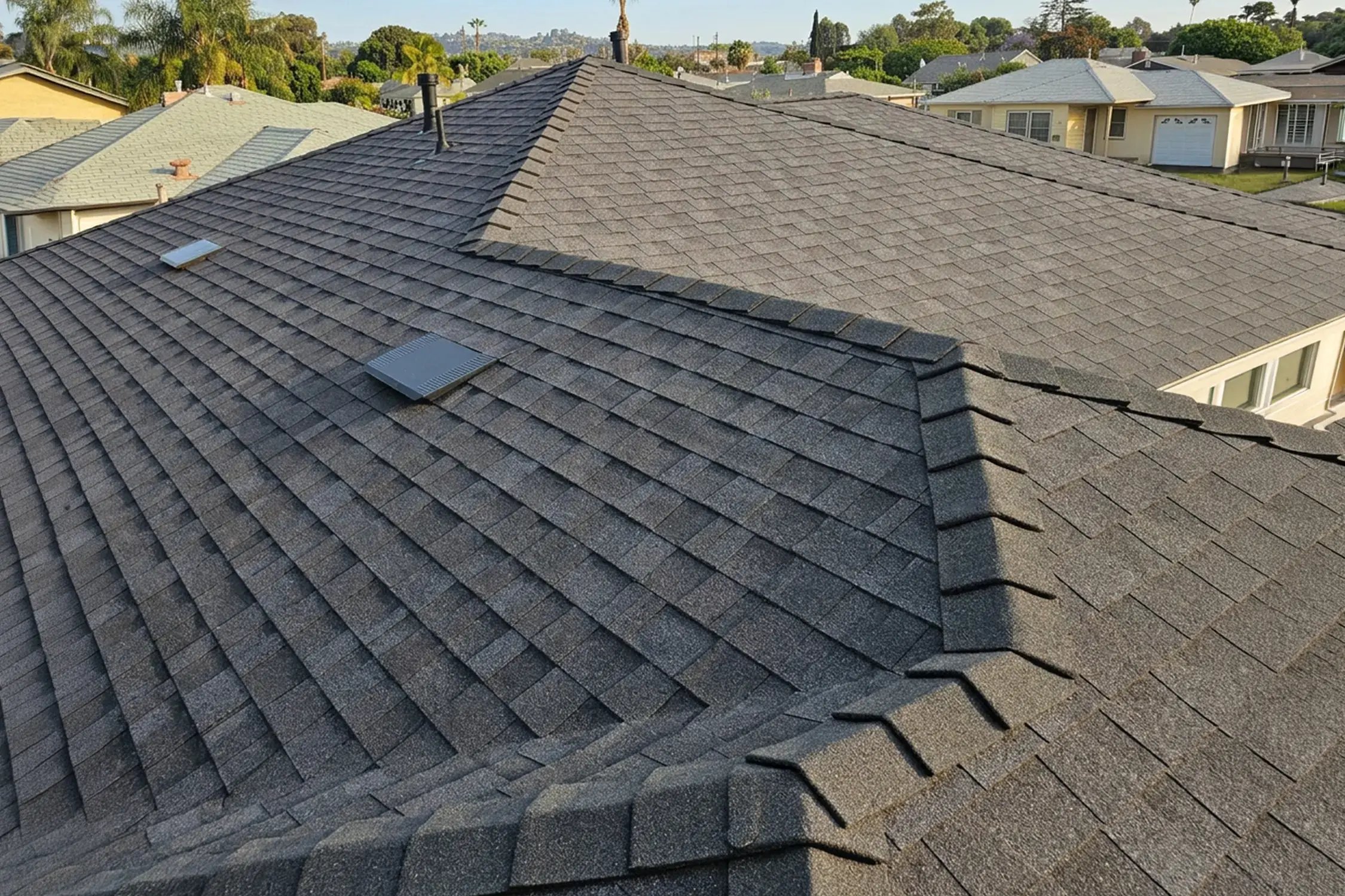 Dark charcoal architectural shingle roof with ridge venting after a full roof replacement in Whittier