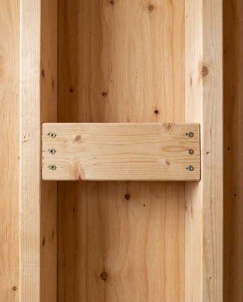 Solid horizontal blocking fastened between wood wall studs before shower substrate is installed