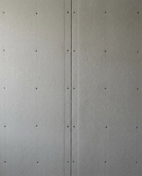 Gray cement backer board panels screwed over framing with a visible seam before waterproofing