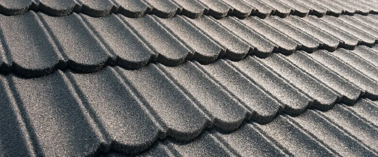 Charcoal stone-coated metal roofing finish sample with a granulated, shake-style textured surface