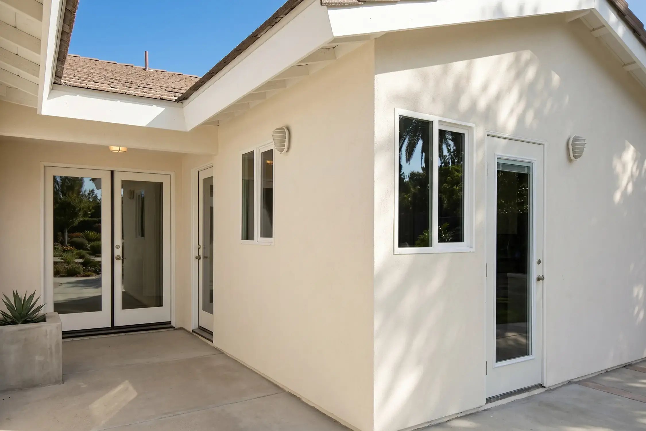 Smooth tan stucco finish on a single-story home after exterior repair, Hybrid Renovations stucco contractor