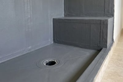 Waterproofing membrane over the shower pan, banded corners and bench before tile — Hybrid Renovations