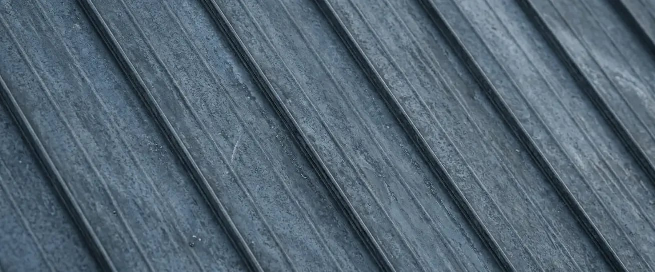 Weathered zinc blue-gray metal roofing finish sample with a mottled, aged patina texture