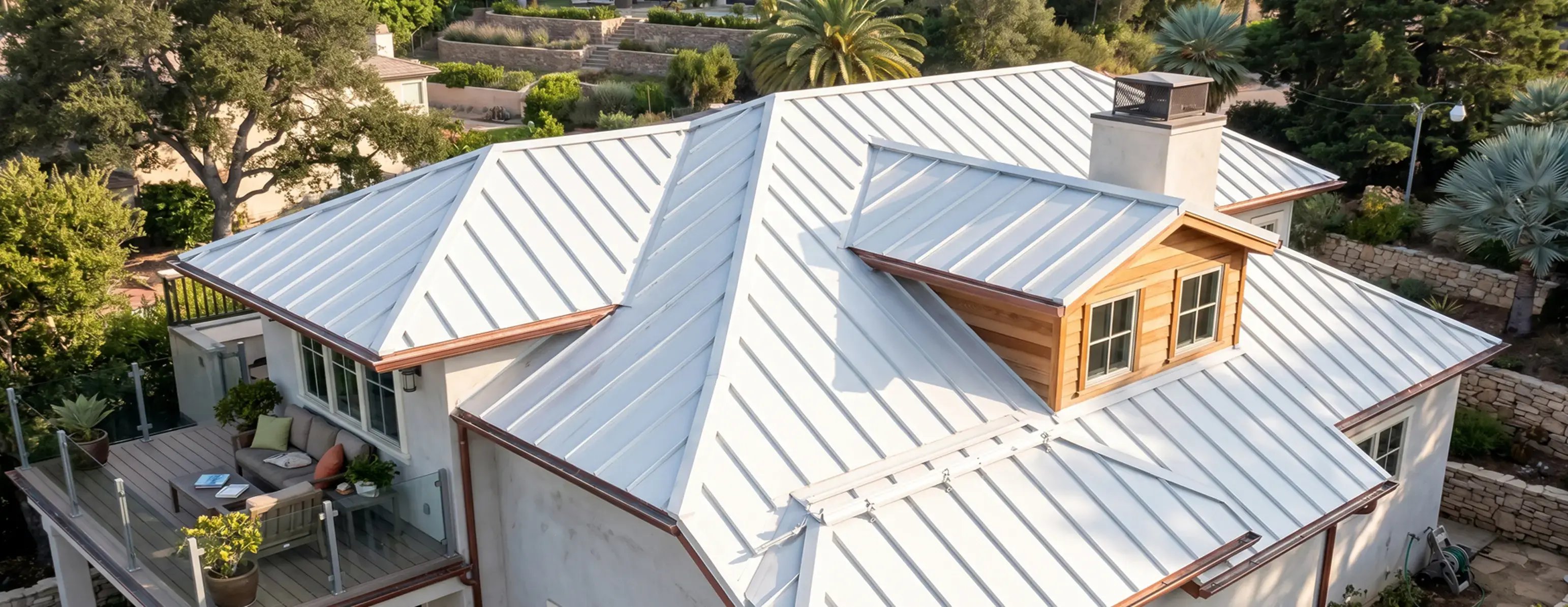 White standing seam metal roof with dormer and chimney on a single-family home — Hybrid Renovations roofing contractor